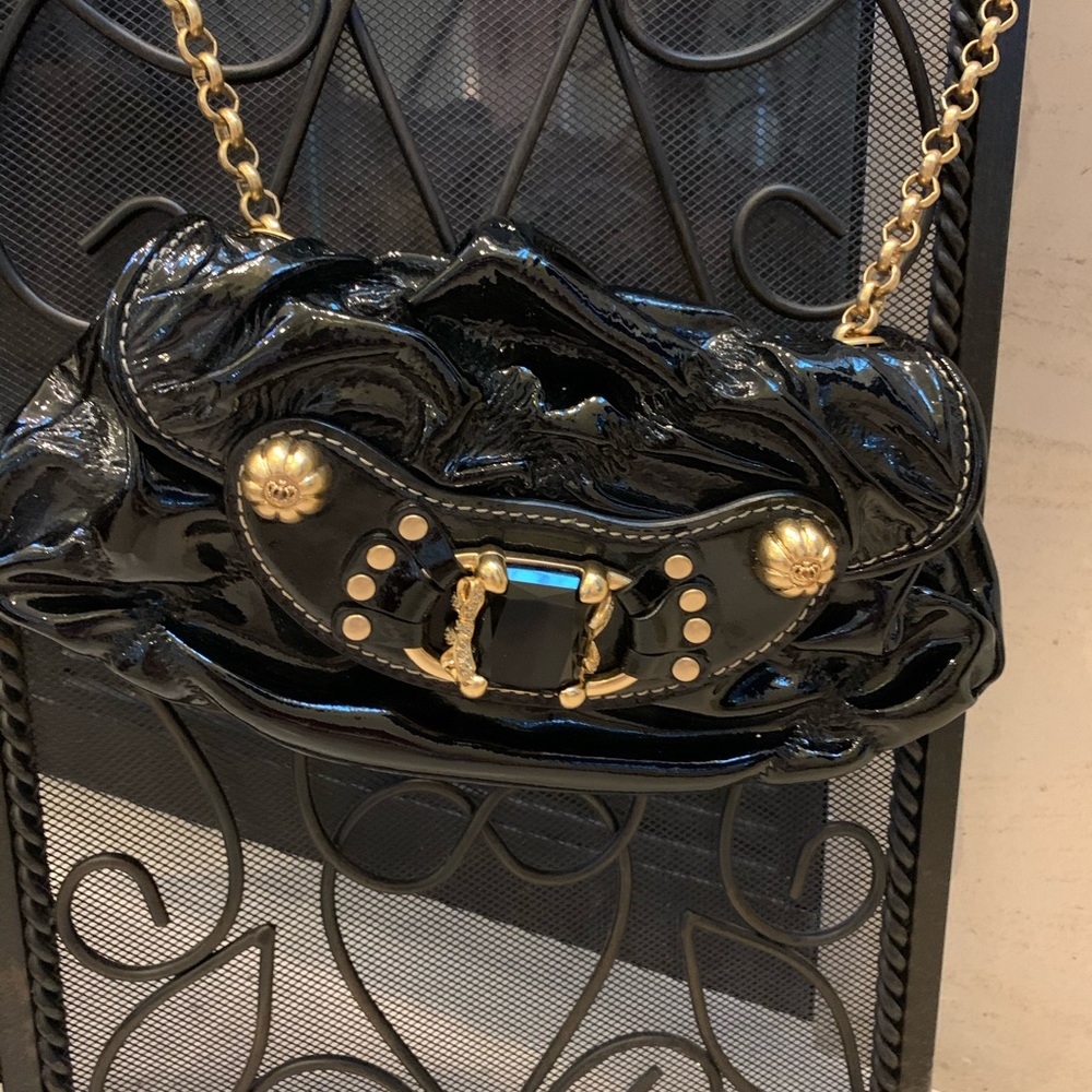Patent leather bag with crossbody gold strap.